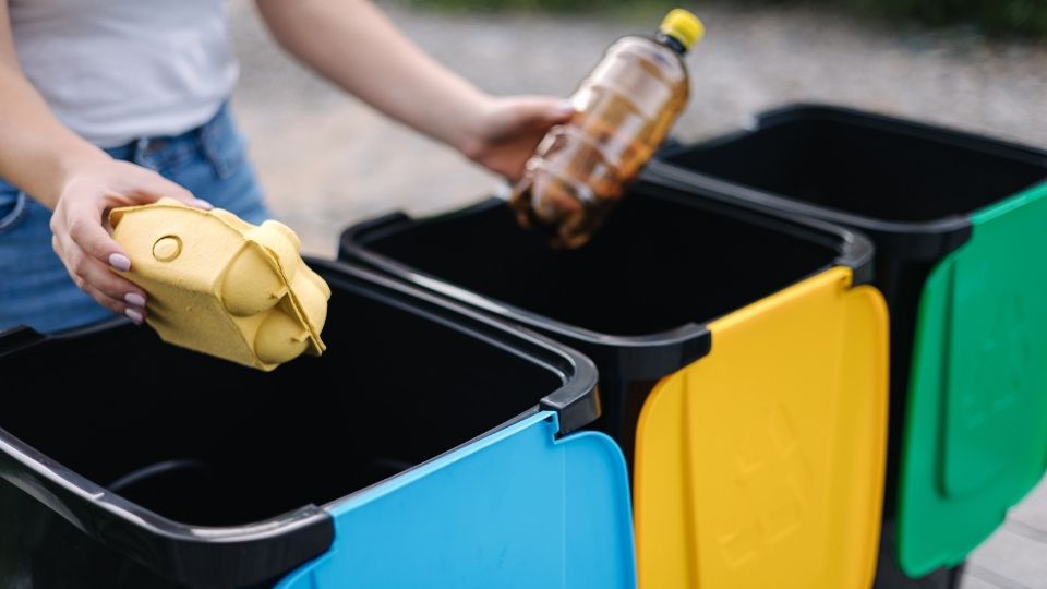 resident sorting cardboard and plastics into separate boxes