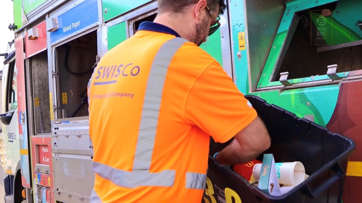 Recycling crew emptying box of plastics into vehicle
