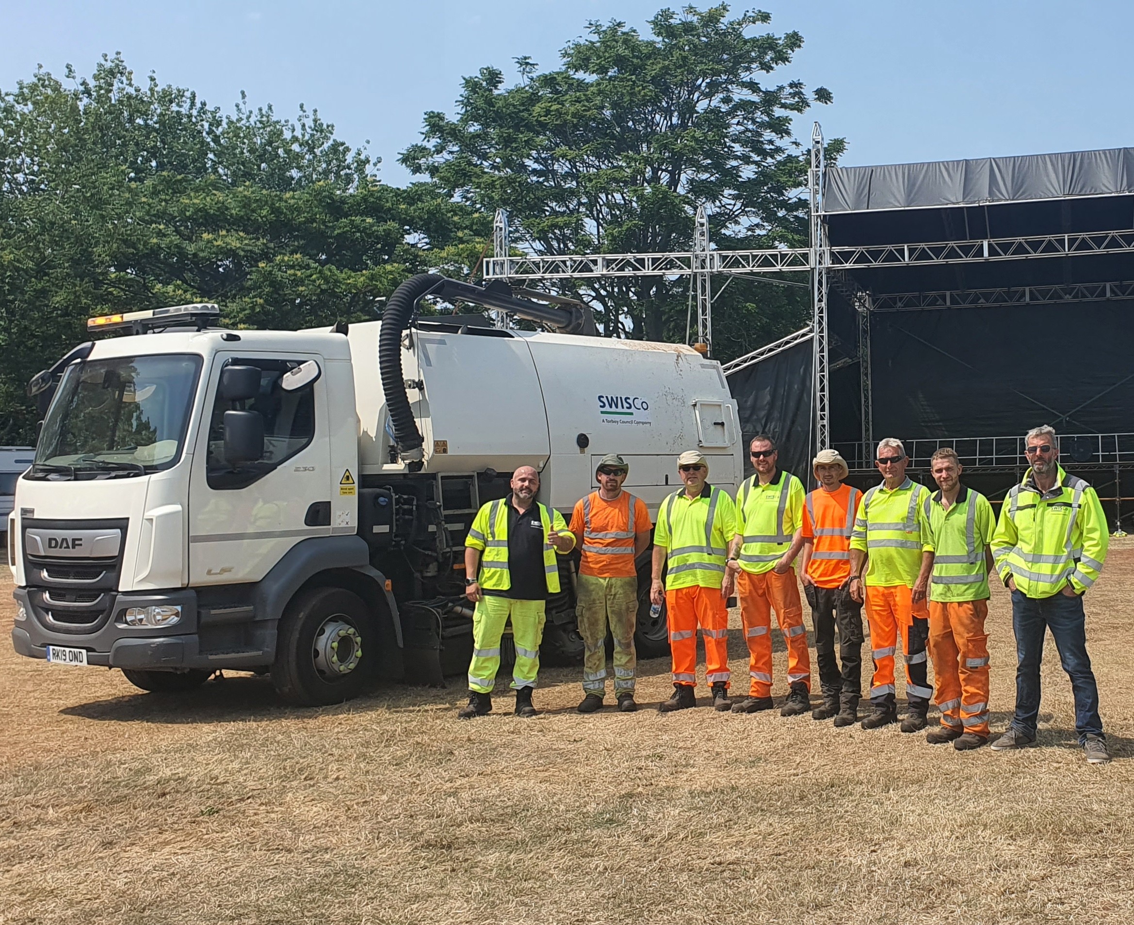SWISCo event waste team posing for a photograph next to a road sweeper at Electric Bay festival