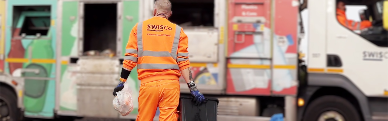 recycling crew holding black recycling box with vehicle in background